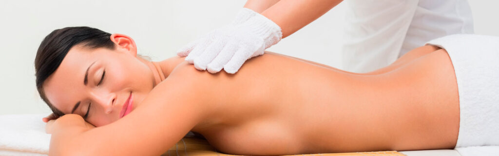 Frau liegt auf einer Liege und wird massiert