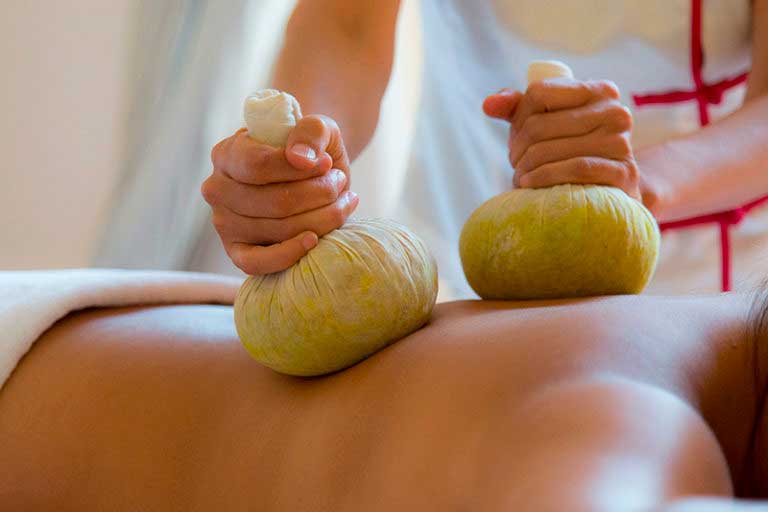 Massage auf einem Rücken mit Baumwollsäckchen