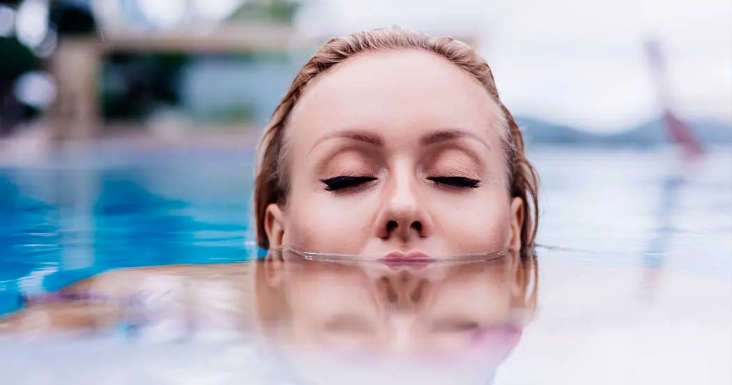 Fau schwimmend im Wasser mit Kopf teilweise im Wasser und geschlossenen Augen