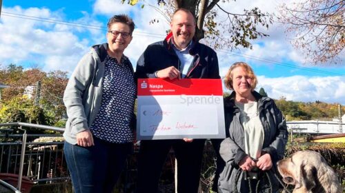 3Personen die einen übergroße Spendenquittung halten