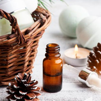 Fläschchen mit ätherischem Öl und Kerze im Hintergrund